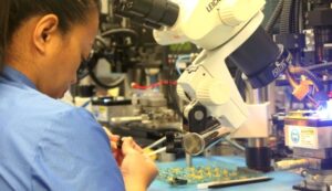 Woman in a lab working on building optical components.